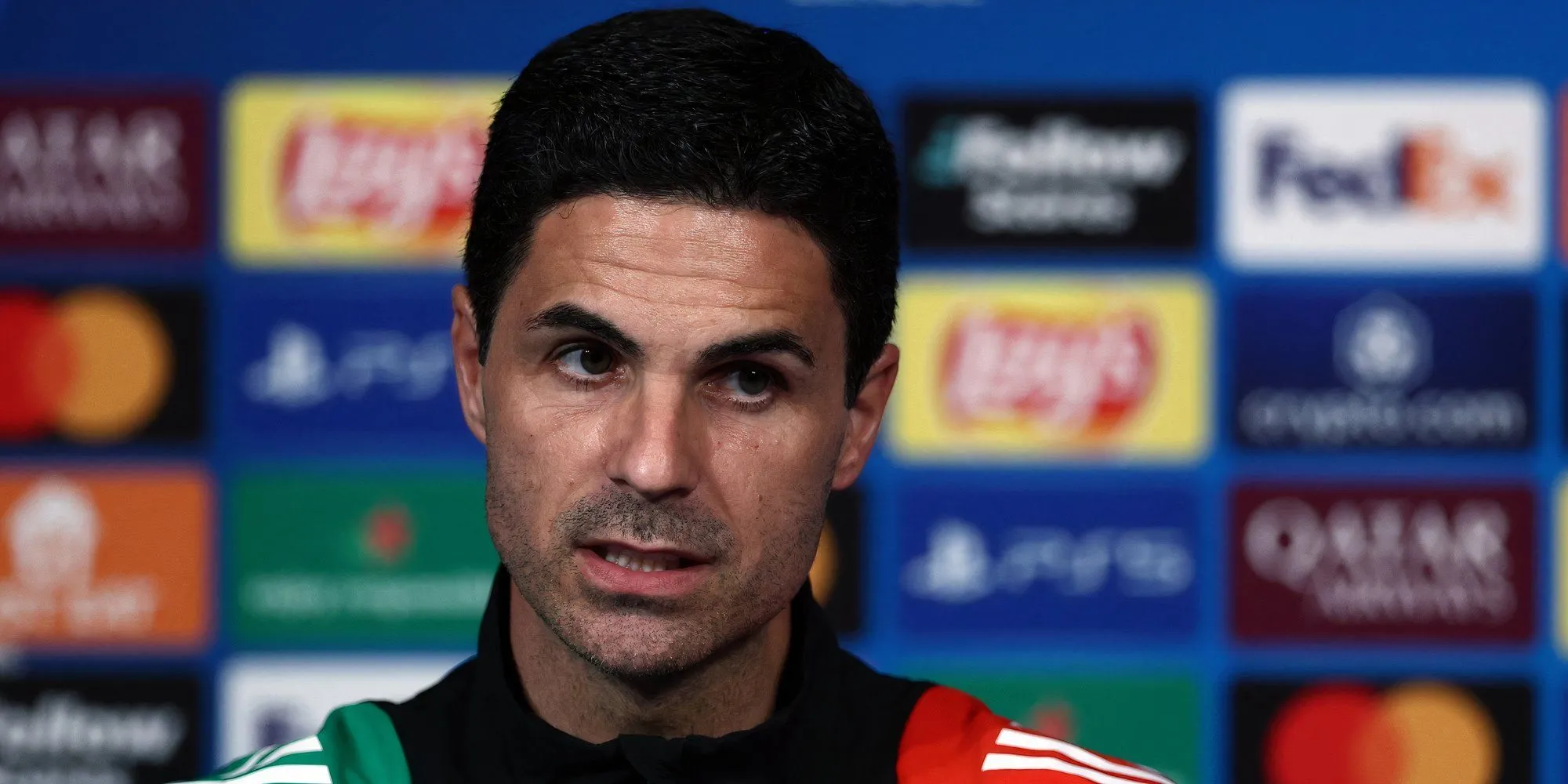 Huấn luyện viên Mikel Arteta của Arsenal trong một buổi họp báo, gương mặt đầy suy tư sau những bình luận gây tranh cãi.