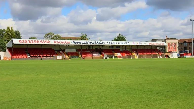 Khán đài chính có mái che với ghế đỏ tại sân Park View Road, dành cho Welling United