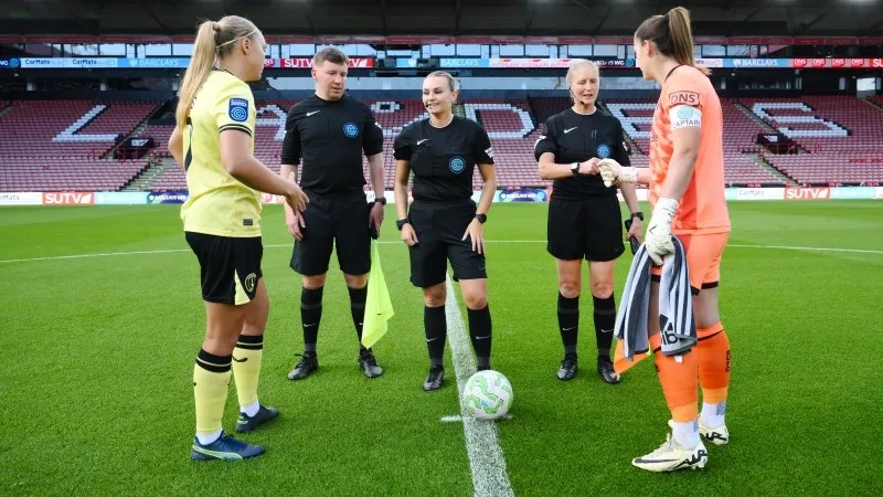 Trọng tài tung đồng xu và xác định đội giao bóng tại vòng tròn trung tâm.